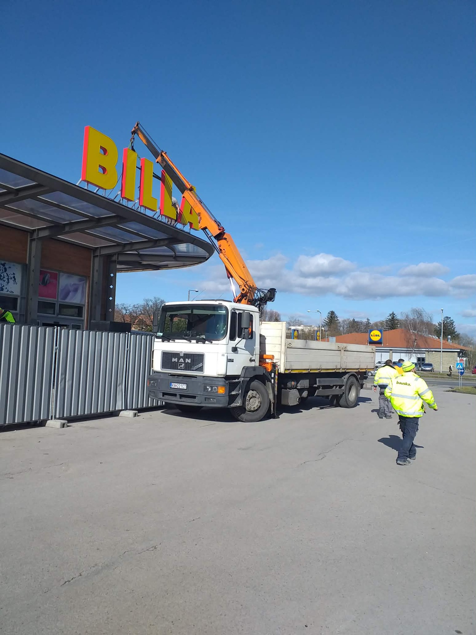 Práce s hydraulickou rukou pri obchodnom objekte
